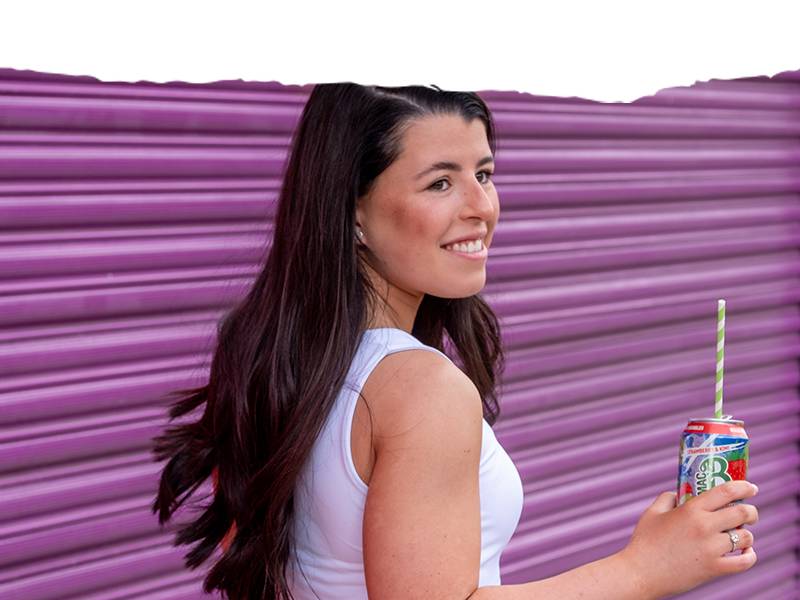 A young woman drinking from a can of sparkling Macb water with a straw